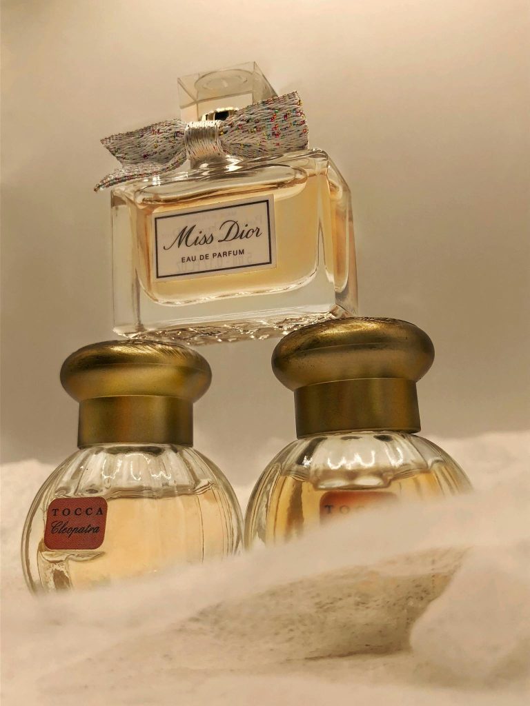 Three elegant perfume bottles arranged on a soft white background. Luxurious display.