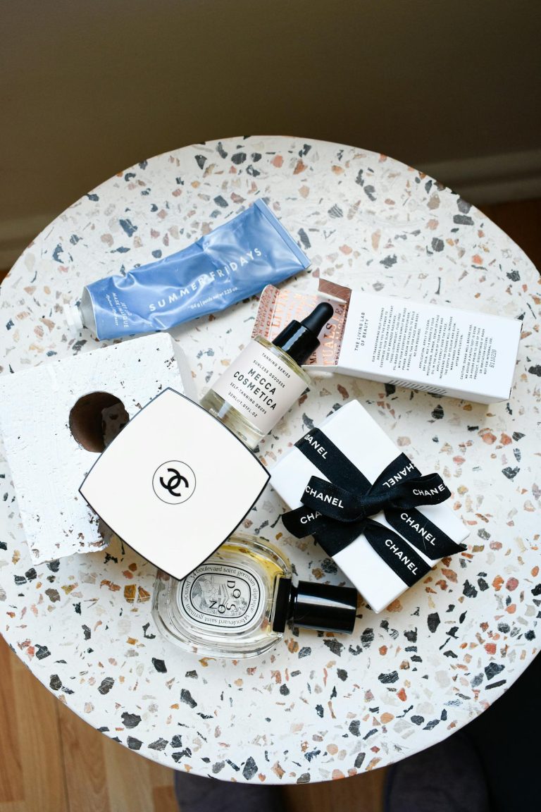 Top view of luxury cosmetics on a terrazzo table, featuring Chanel and other brands.